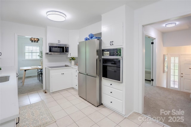 303 Odell St, Kannapolis, NC 28083 - kitchen with black appliances, light countertops, light colored carpet, and white cabinetry