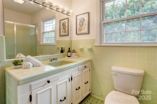 303 Odell St, Kannapolis, NC 28083 - full bathroom featuring vanity, a shower stall, tile walls, and a wainscoted wall