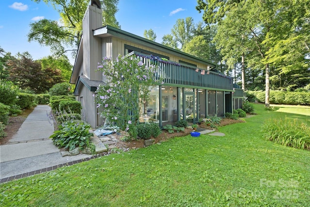 28 Toxaway Pt Unit B7, Lake Toxaway, NC 28747 - rear view of house featuring a lawn, a chimney, and a sunroom