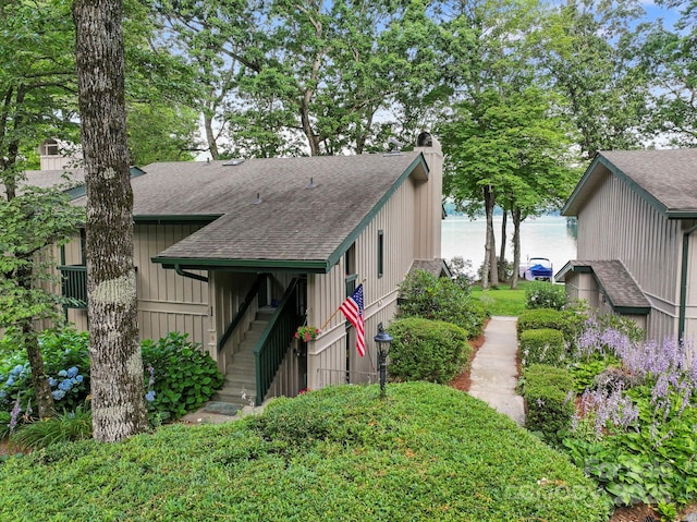 28 Toxaway Pt Unit B7, Lake Toxaway, NC 28747 - view of front facade with a shingled roof, a chimney, and a water view