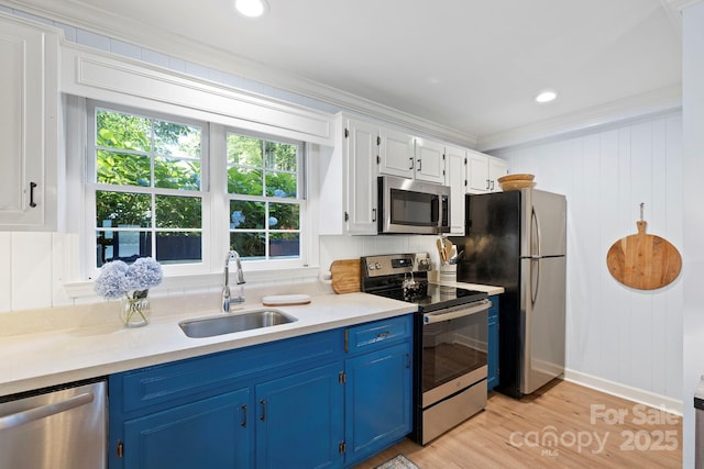 28 Toxaway Pt Unit B7, Lake Toxaway, NC 28747 - kitchen with appliances with stainless steel finishes, blue cabinets, crown molding, light countertops, and light wood-type flooring