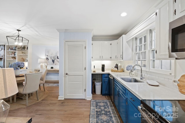 28 Toxaway Pt Unit B7, Lake Toxaway, NC 28747 - kitchen featuring blue cabinetry, appliances with stainless steel finishes, a chandelier, ornamental molding, and white cabinets