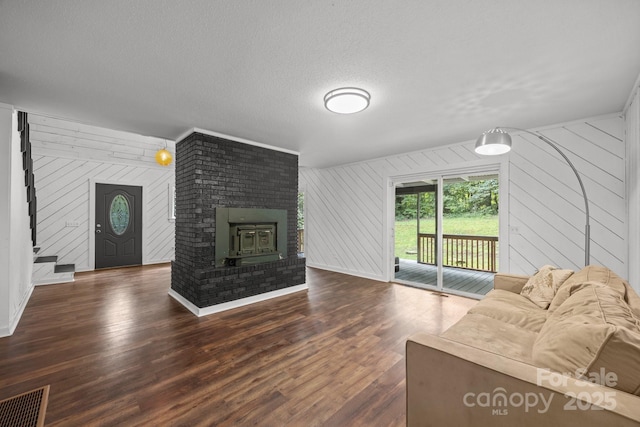 3276 Howard Gap Rd, Hendersonville, NC 28792 - living room with wood finished floors, wooden walls, a brick fireplace, and a textured ceiling
