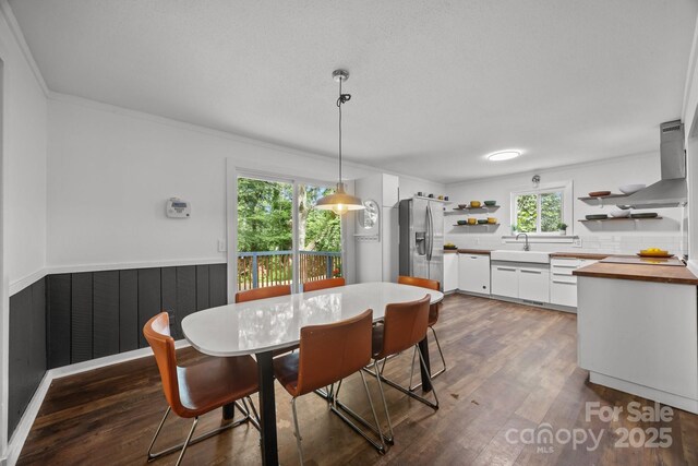 3276 Howard Gap Rd, Hendersonville, NC 28792 - dining area featuring dark wood finished floors, crown molding, and wainscoting