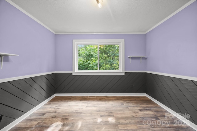 3276 Howard Gap Rd, Hendersonville, NC 28792 - spare room featuring wainscoting, wood finished floors, ornamental molding, and wood walls