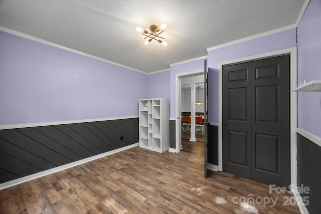 3276 Howard Gap Rd, Hendersonville, NC 28792 - unfurnished bedroom featuring wood finished floors, a textured ceiling, a chandelier, and ornamental molding