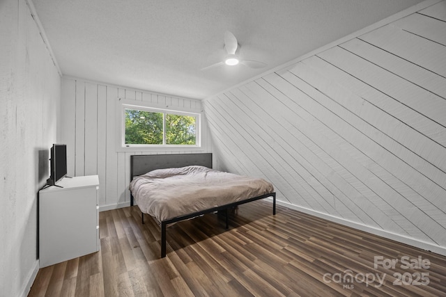 3276 Howard Gap Rd, Hendersonville, NC 28792 - bedroom with dark wood-style floors, a ceiling fan, and wooden walls