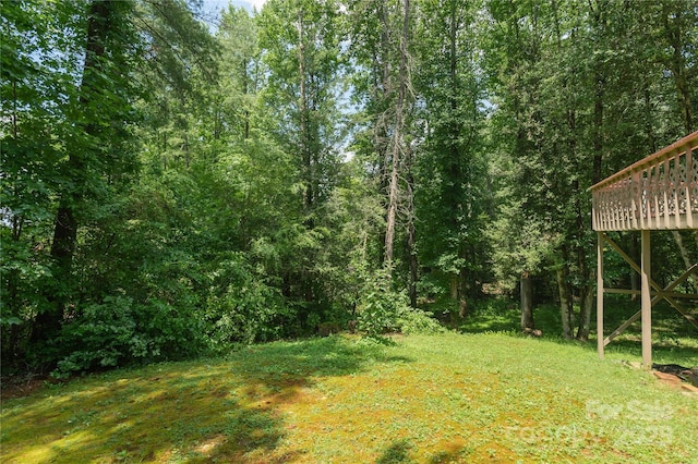 227 Acorn Ln, Pisgah Forest, NC 28768 - view of green lawn with a wooden deck and a view of trees