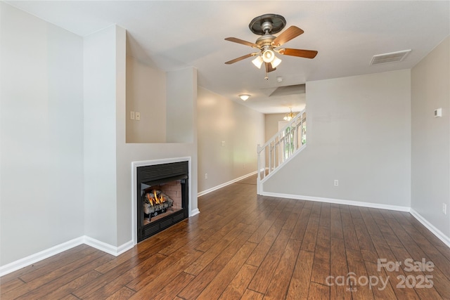 256 Farington Cir Unit 128, Fletcher, NC 28732 - unfurnished living room featuring wood finished floors, stairway, ceiling fan, and a lit fireplace