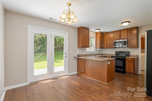 256 Farington Cir Unit 128, Fletcher, NC 28732 - kitchen featuring stainless steel microwave, black electric range, brown cabinetry, and a peninsula