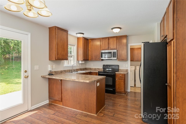 256 Farington Cir Unit 128, Fletcher, NC 28732 - kitchen with appliances with stainless steel finishes, washing machine and clothes dryer, a peninsula, and brown cabinetry