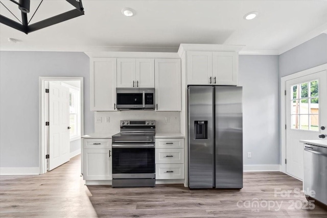 405 E Broad St, Salisbury, NC 28144 - kitchen featuring appliances with stainless steel finishes, light countertops, light wood-type flooring, white cabinetry, and recessed lighting