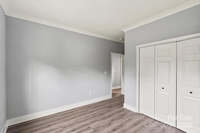 405 E Broad St, Salisbury, NC 28144 - unfurnished bedroom featuring crown molding, a closet, and wood finished floors