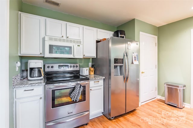 1274 Winding Path Rd, Clover, SC 29710 - kitchen featuring appliances with stainless steel finishes, white cabinets, light wood-type flooring, and light stone counters