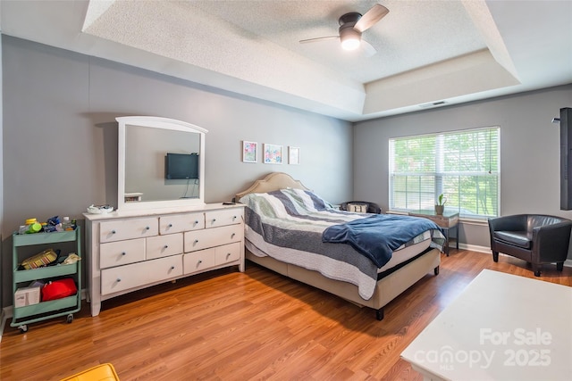 1274 Winding Path Rd, Clover, SC 29710 - bedroom with a tray ceiling, light wood-type flooring, ceiling fan, and a textured ceiling
