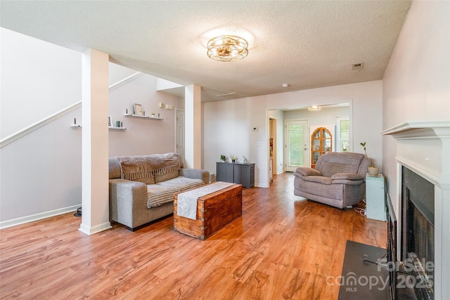 1274 Winding Path Rd, Clover, SC 29710 - living area with light wood finished floors, a textured ceiling, and a fireplace with flush hearth
