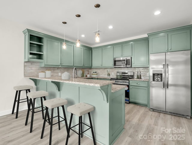 174 Charlie Randall Rd, Lawndale, NC 28090 - kitchen featuring stainless steel appliances, green cabinetry, open shelves, a peninsula, and a breakfast bar area
