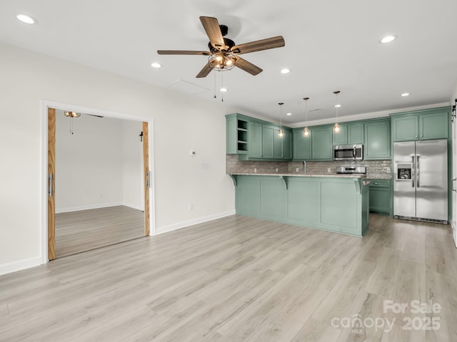 174 Charlie Randall Rd, Lawndale, NC 28090 - kitchen featuring green cabinetry, stainless steel appliances, ceiling fan, a peninsula, and decorative backsplash