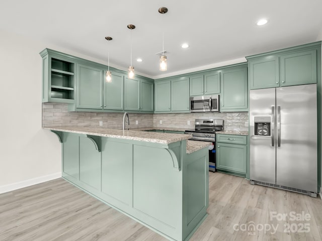 174 Charlie Randall Rd, Lawndale, NC 28090 - kitchen featuring appliances with stainless steel finishes, green cabinets, a peninsula, open shelves, and a breakfast bar area