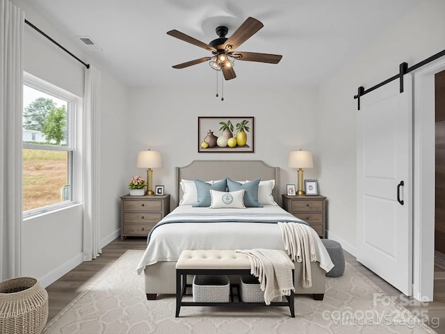 174 Charlie Randall Rd, Lawndale, NC 28090 - bedroom with a barn door, wood finished floors, and a ceiling fan