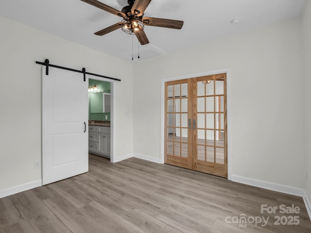 174 Charlie Randall Rd, Lawndale, NC 28090 - empty room featuring a barn door, a ceiling fan, and light wood-style flooring