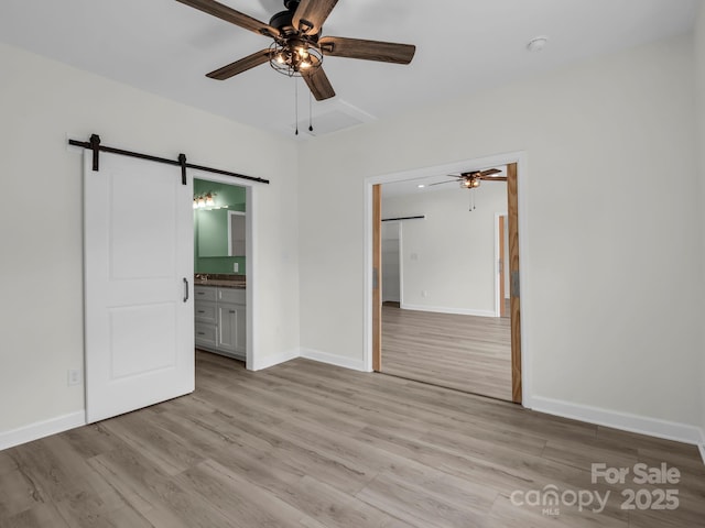 174 Charlie Randall Rd, Lawndale, NC 28090 - unfurnished bedroom featuring a barn door, light wood-type flooring, ensuite bathroom, and a ceiling fan