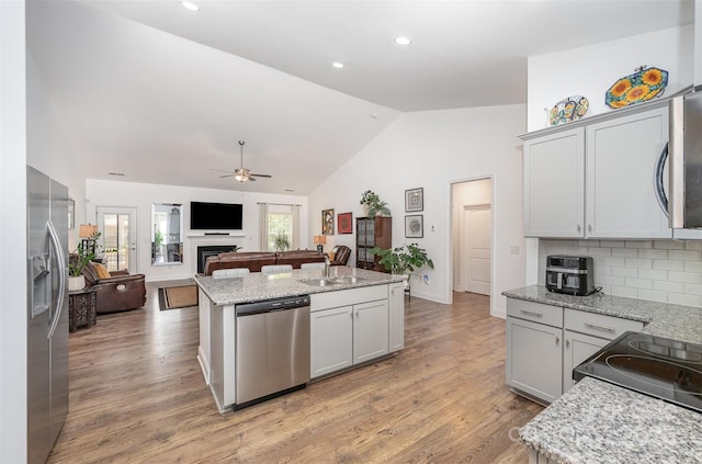 7718 Village Pkwy, Locust, NC 28097 - kitchen featuring stainless steel appliances, ceiling fan, open floor plan, tasteful backsplash, and an island with sink