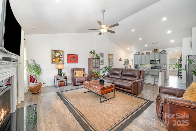 7718 Village Pkwy, Locust, NC 28097 - living area featuring lofted ceiling, a ceiling fan, a lit fireplace, recessed lighting, and light wood-style flooring