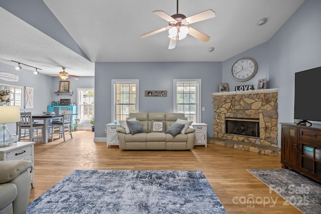 315 Talon Dr, Salisbury, NC 28147 - living room featuring ceiling fan, vaulted ceiling, a fireplace, wood finished floors, and a textured ceiling