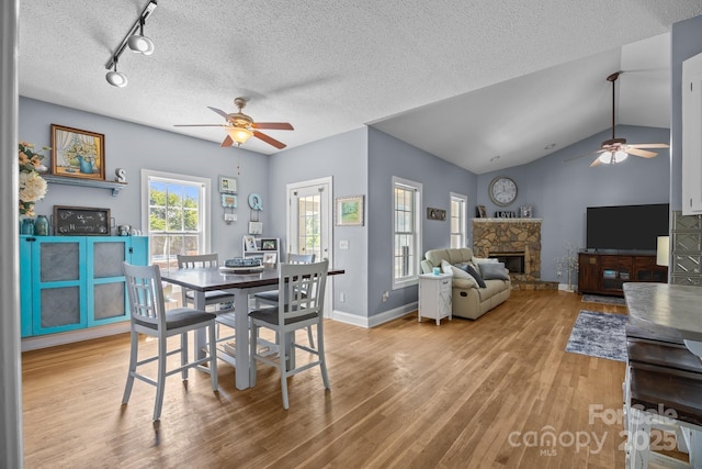 315 Talon Dr, Salisbury, NC 28147 - dining space featuring a ceiling fan, wood finished floors, a fireplace, vaulted ceiling, and rail lighting