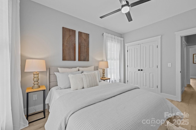 8225 Ballymore Ct, Huntersville, NC 28078 - bedroom with light wood-type flooring, a closet, and a ceiling fan