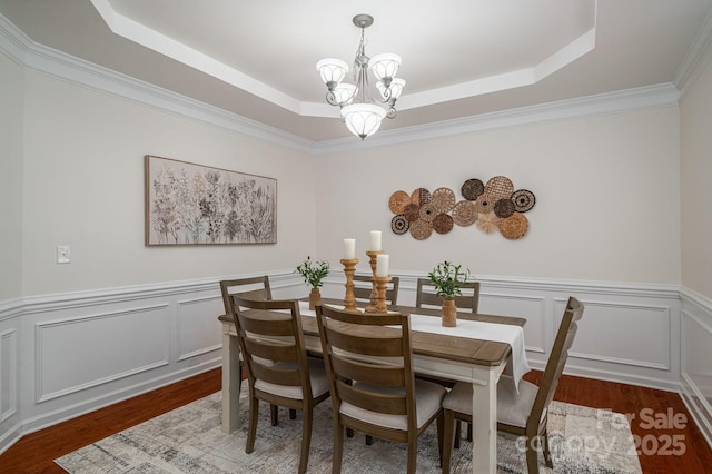 734 Naramore St, Davidson, NC 28036 - dining space with a chandelier, a tray ceiling, wood finished floors, a wainscoted wall, and crown molding