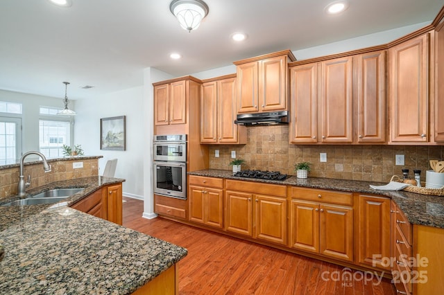 734 Naramore St, Davidson, NC 28036 - kitchen with double oven, black gas stovetop, under cabinet range hood, backsplash, and light wood-style floors