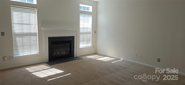 162 Autumn Falls Dr, Lake Wylie, SC 29710 - unfurnished living room featuring carpet flooring, a fireplace with flush hearth, and plenty of natural light
