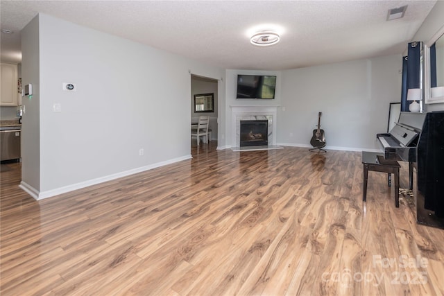 2085 Chapel Creek Rd SW, Concord, NC 28025 - unfurnished living room featuring wood finished floors, a textured ceiling, and a premium fireplace