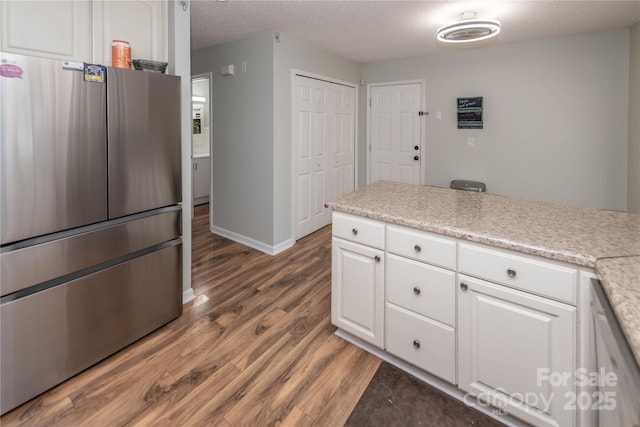 2085 Chapel Creek Rd SW, Concord, NC 28025 - kitchen featuring freestanding refrigerator, wood finished floors, white cabinets, light countertops, and a textured ceiling