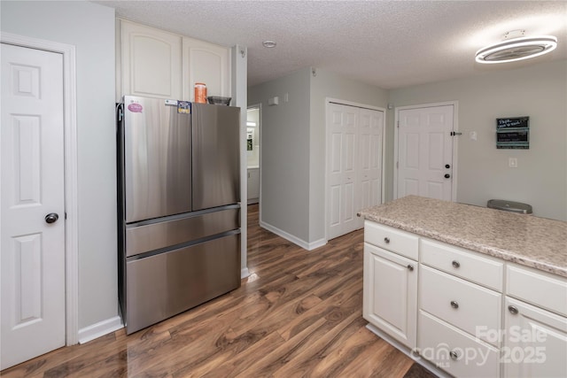 2085 Chapel Creek Rd SW, Concord, NC 28025 - kitchen featuring freestanding refrigerator, dark wood-style flooring, a textured ceiling, white cabinets, and light countertops