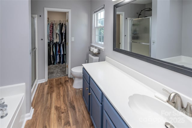 2085 Chapel Creek Rd SW, Concord, NC 28025 - full bath featuring a stall shower, wood finished floors, vanity, a spacious closet, and a garden tub