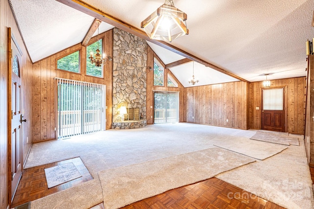 366 Charlois St, Hudson, NC 28638 - unfurnished living room featuring a textured ceiling, a chandelier, wood walls, a fireplace, and beam ceiling