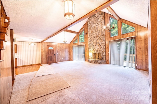 366 Charlois St, Hudson, NC 28638 - unfurnished living room with a textured ceiling, wood walls, plenty of natural light, high vaulted ceiling, and carpet