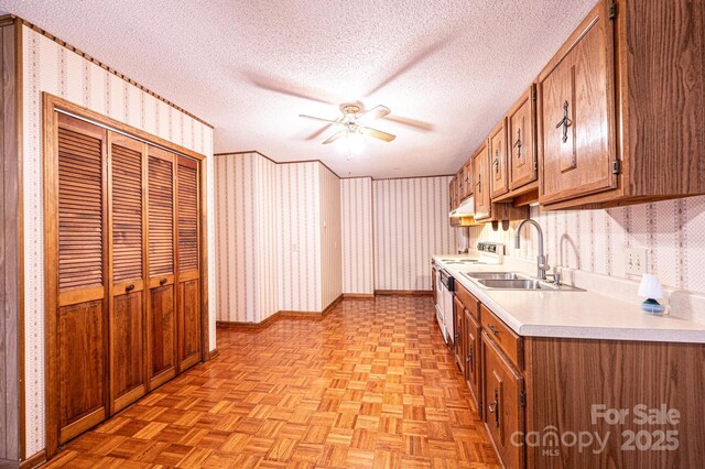 366 Charlois St, Hudson, NC 28638 - kitchen with a ceiling fan, white range with electric cooktop, light countertops, brown cabinets, and wallpapered walls