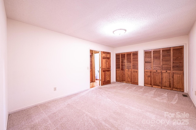 366 Charlois St, Hudson, NC 28638 - unfurnished bedroom with carpet, two closets, and a textured ceiling