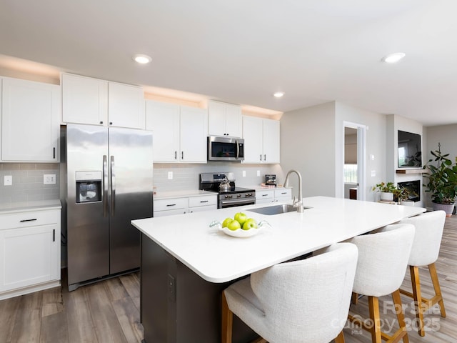 2796 Legacy Ridge Ln, Catawba, NC 28609 - kitchen with appliances with stainless steel finishes, a center island with sink, a kitchen breakfast bar, decorative backsplash, and recessed lighting