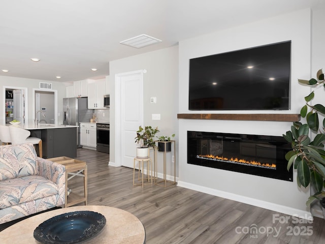 2796 Legacy Ridge Ln, Catawba, NC 28609 - living area with wood finished floors, a glass covered fireplace, and recessed lighting