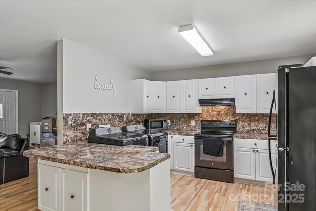 1631 Berkley St SW, Lenoir, NC 28645 - kitchen with black appliances, washer and dryer, a peninsula, light wood-style floors, and white cabinetry
