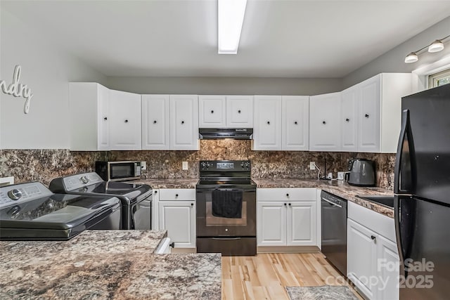 1631 Berkley St SW, Lenoir, NC 28645 - kitchen featuring black appliances, washing machine and dryer, under cabinet range hood, and white cabinetry