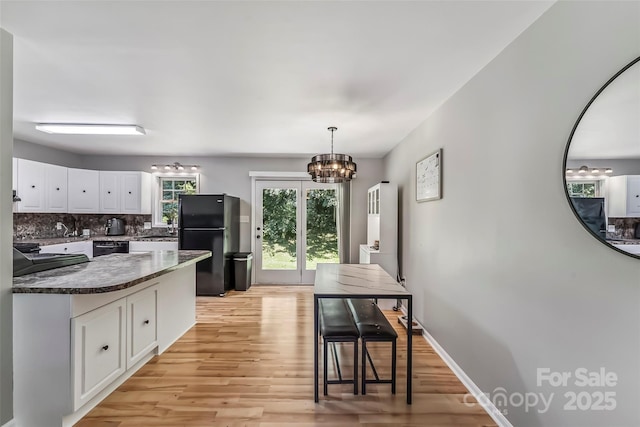 1631 Berkley St SW, Lenoir, NC 28645 - kitchen featuring black appliances, white cabinetry, light wood-type flooring, tasteful backsplash, and a chandelier
