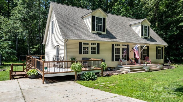 7648 Forest Oak Dr, Denver, NC 28037 - cape cod home with a front lawn, a deck, a shingled roof, and view of wooded area