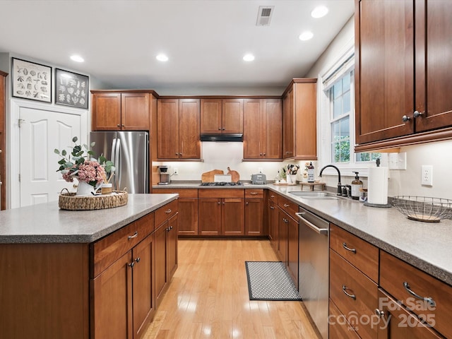 13930 Daltrey Ln, Charlotte, NC 28277 - kitchen with appliances with stainless steel finishes, light wood-type flooring, under cabinet range hood, recessed lighting, and brown cabinetry