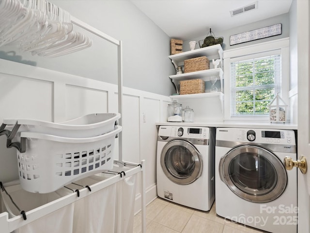 13930 Daltrey Ln, Charlotte, NC 28277 - laundry area with separate washer and dryer, light tile patterned floors, a wainscoted wall, and a decorative wall